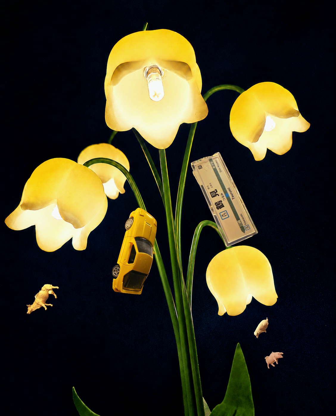 A luminous bouquet of yellow bell flowers arranged with a miniature car, a Tsurumi train sign, and small animals against a midnight-blue background